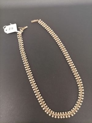 a necklace with pearls and gold beads on a black surface