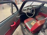 an old car with a red seat and a steering