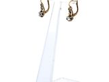 un gros plan d'une paire de boucles d'oreilles posées sur un présentoir transparent