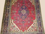 a red and blue rug with a medallion design on it
