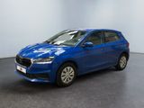 Une voiture bleue est garée dans une pièce aux murs blancs.