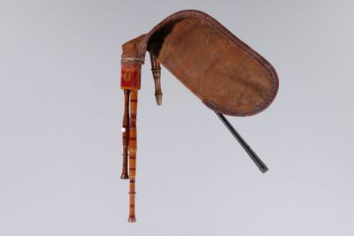un vieux sac en cuir muni d'une poignée en bois et contenant une canne