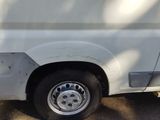 a white van with a flat tire parked in a parking lot