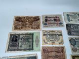 some old paper money sitting on top of a white table