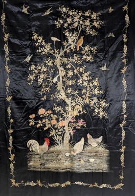 une image représentant une tenture murale brodée en noir et or, ornée d'oiseaux, de fleurs et d'un arbre