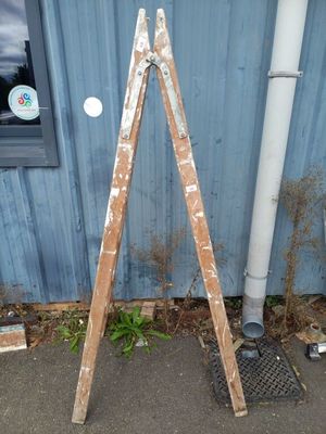 une échelle en bois appuyée contre un immeuble bleu