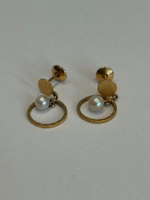 gros plan d'une paire de boucles d'oreilles sur une surface blanche
