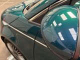 reflection of a car in a parking meter on the side of the road