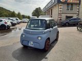une petite voiture bleue garée devant un immeuble