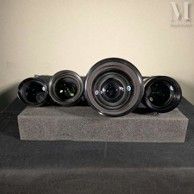 five camera lenses sitting on top of a stone block