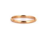 gros plan d'une bague en or sur fond blanc