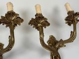 pair of antique brass wall sconces with candles on each of them