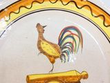 une assiette décorative sur laquelle est représenté un coq