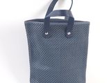 a blue tote bag with leather handles on a white background
