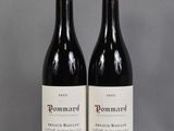 two bottles of red wine sitting next to each other on a table