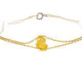a close up of a gold chain bracelet with a heart on it