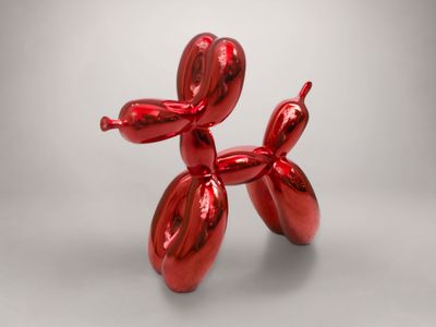 une sculpture représentant un chien en ballon rouge, posée sur une table