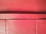 a close up of a red leather purse with a zipper