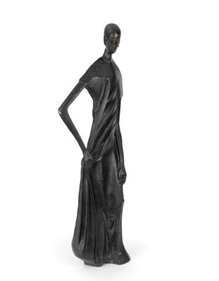 la statue d'une femme se tient debout, les mains sur les hanches