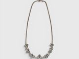 un collier en argent avec des perles et une chaîne sur fond blanc