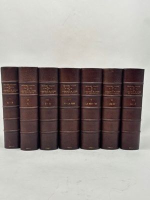 six vieux livres alignés sur une surface blanche