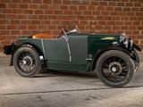 a vintage car parked in front of a brick wall