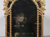 une image représentant un miroir à cadre doré orné d'une tête de lion