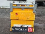 une boîte aux lettres jaune posée par terre devant un immeuble