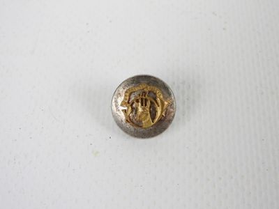 un gros plan d'un bouton en métal sur une surface blanche