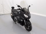 une moto noire garée dans une pièce aux murs blancs