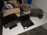 une table sur laquelle se trouvent un ordinateur portable, une imprimante et d'autres appareils électroniques