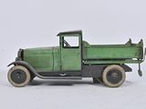 a green toy truck that is sitting on a white surface