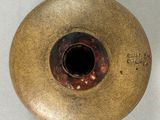 a brown vase that has a hole in the middle of it