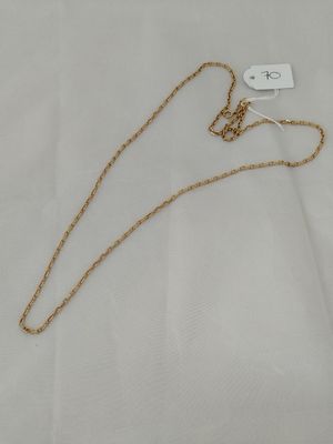 a gold necklace with a chain on a white background