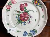 a plate with flowers on it sitting on a wooden table