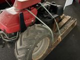 a red tractor that is sitting on a pallet