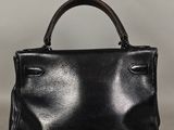 Le petit sac à main noir est posé sur la table.