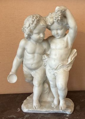 une statue représentant un garçon et une fille posée sur une table