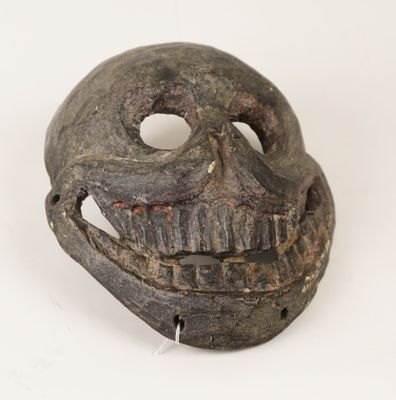 an old wooden mask with a hole in the middle of it