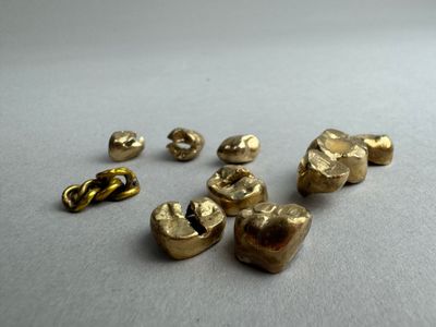 plusieurs pièces de métal de couleur dorée sont disposées sur une surface blanche