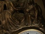 a gold clock with roman numerals on the face