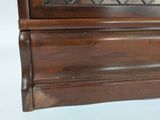 a wooden cabinet with a glass door on top of it