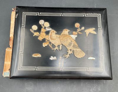 une photo d'une boîte noire et dorée ornée d'oiseaux