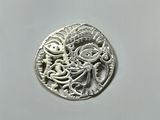 a close up of a silver coin on a white surface