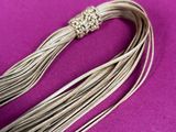 a close up of a long silver necklace with a flower on it