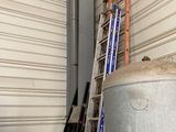 several ladders are leaning against a wall in a storage area