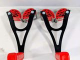 pair of red and black handles with red wheels on a white surface