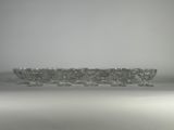 six verres à vin en cristal posés sur une surface blanche, avec une lumière en arrière-plan