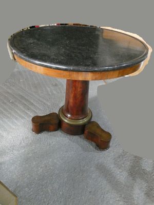 une petite table avec un plateau en marbre posée sur un sol recouvert de moquette