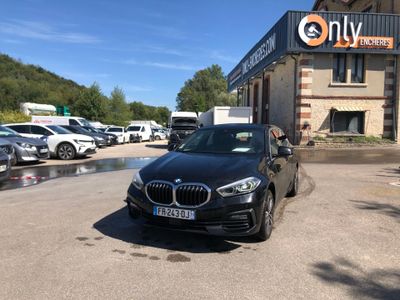 the black bmw car is parked in front of a building
